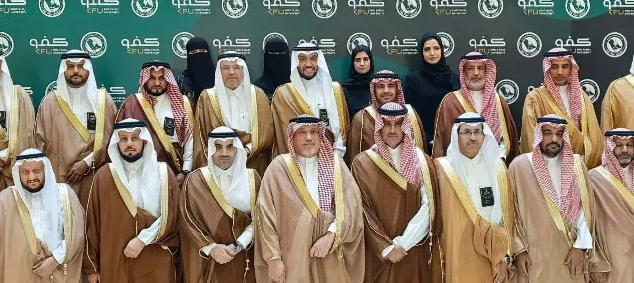 مجموعة وكلاء وممثلي الجامعات يقفون لالتقاط صورة جماعية أمام خلفية تحمل شعار الجامعة